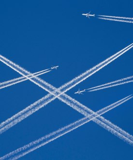 A photo illustration of a sky filled with airplanes releasing contrails behind them.
