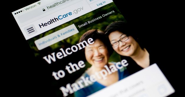 A photo of a phone screen showing the HealthCare.gov website.