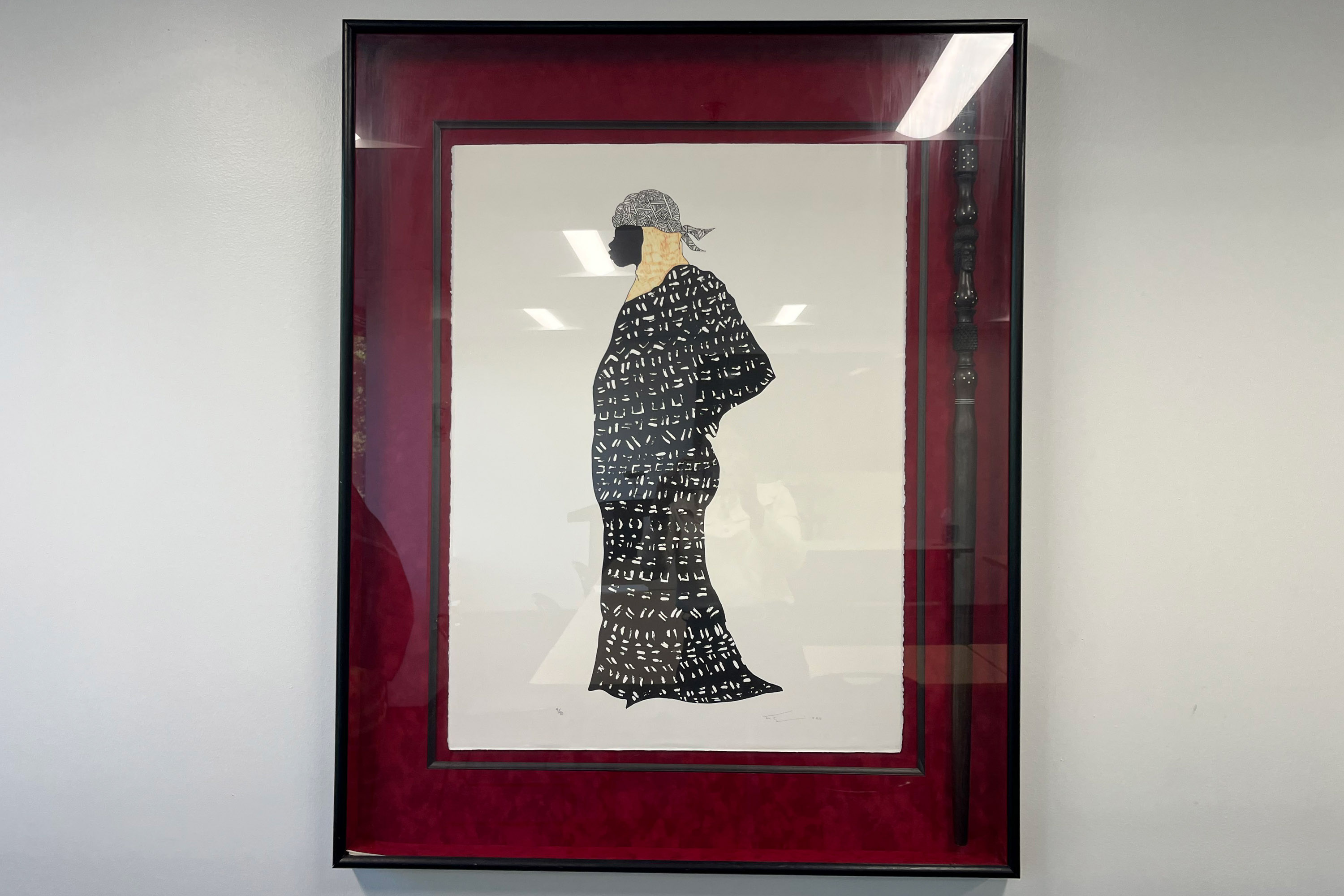 A photo of a piece of artwork depicting a Black woman in a headscarf and robe.
