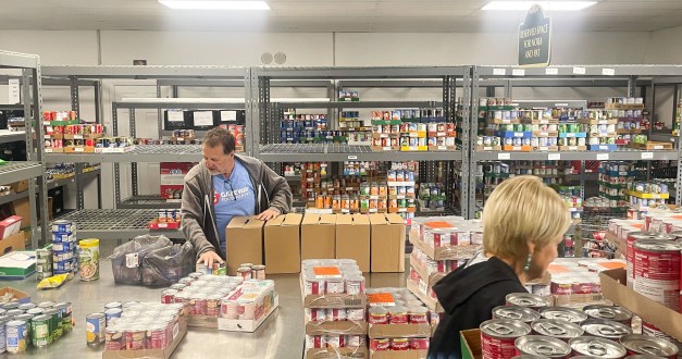 A man sorts through a food delivery at a food bank