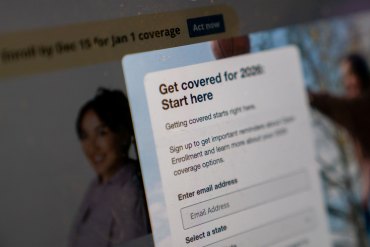 A photo of HealthCare.gov's website. A pop-up form reads, "Get covered for 2026. Start here."
