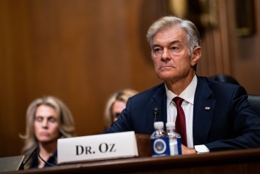 A photo showing Mehmet Oz sitting at a table in a court room.