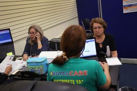 A photo of enrollment agents with laptops helping people shop for Obamacare plans.
