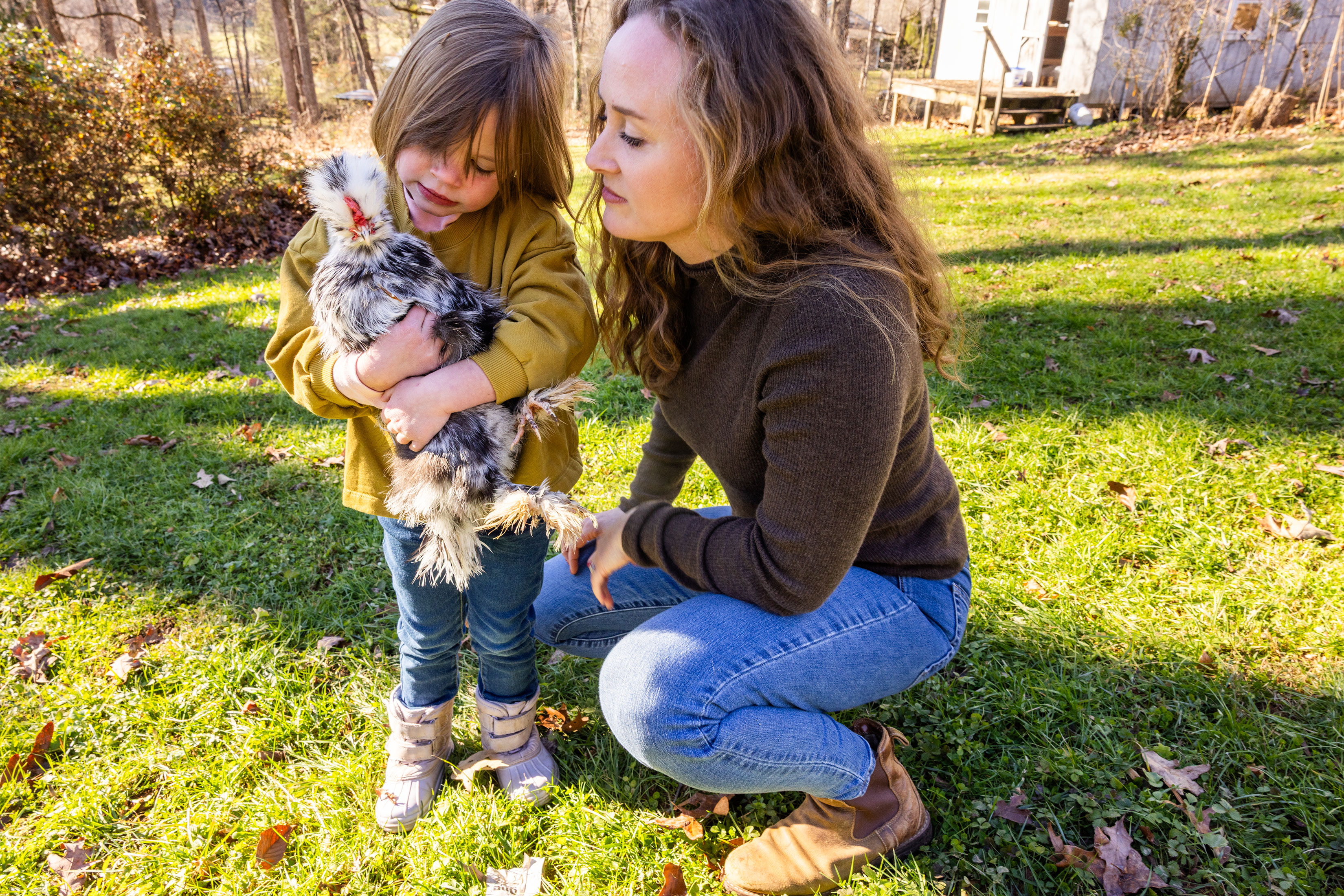 A photo of Kellyn Haight with her daughter. Her daughter is holding a chicken.