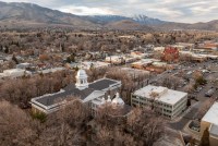Aerial view of buildings in a city with foothills and mountains in the background
