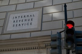 Photo of the exterior of a stone building with a sign that says "Internal Revenue Service" along with a traffic light next to it