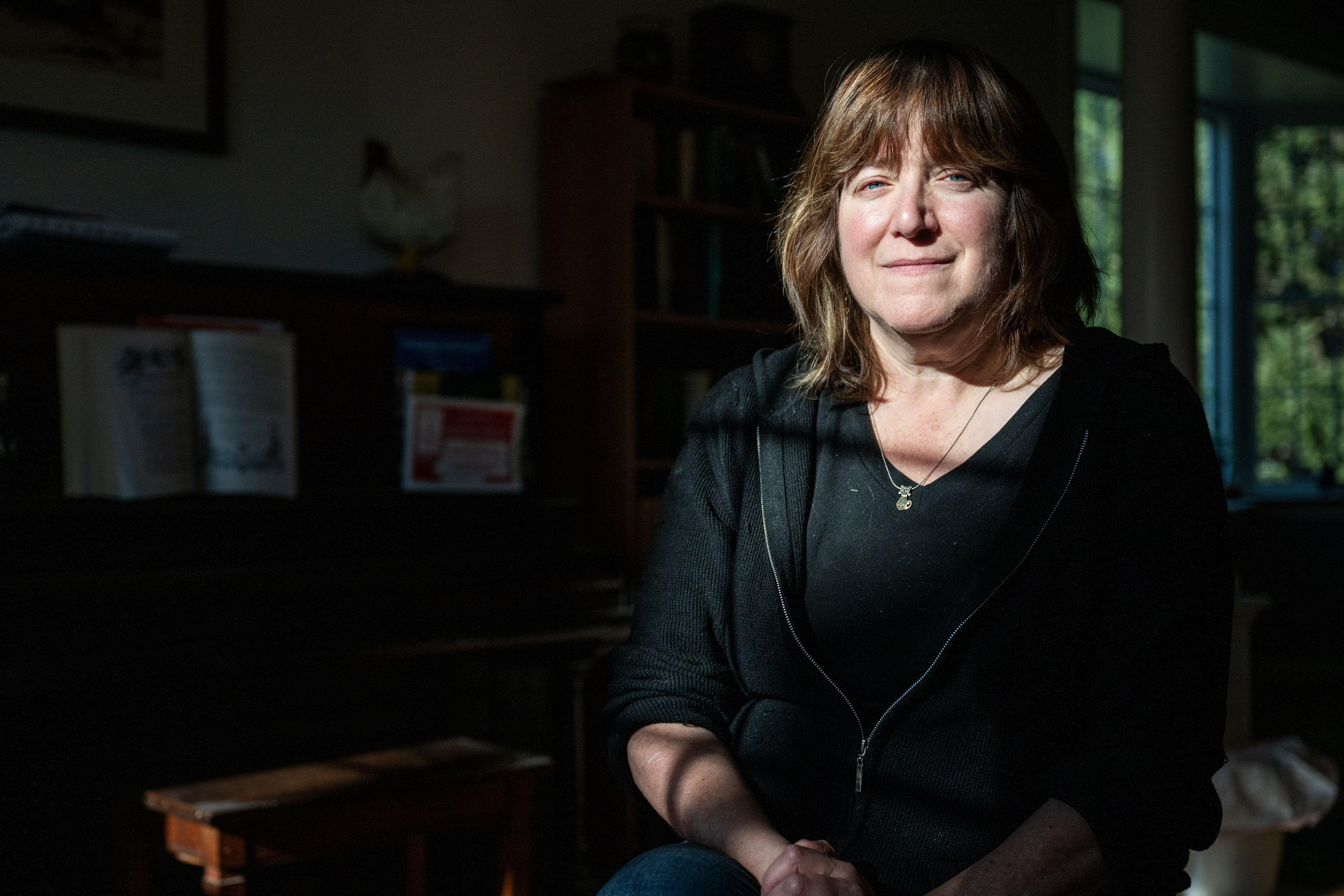 Jennifer Troyer sits in her home by a piano.
