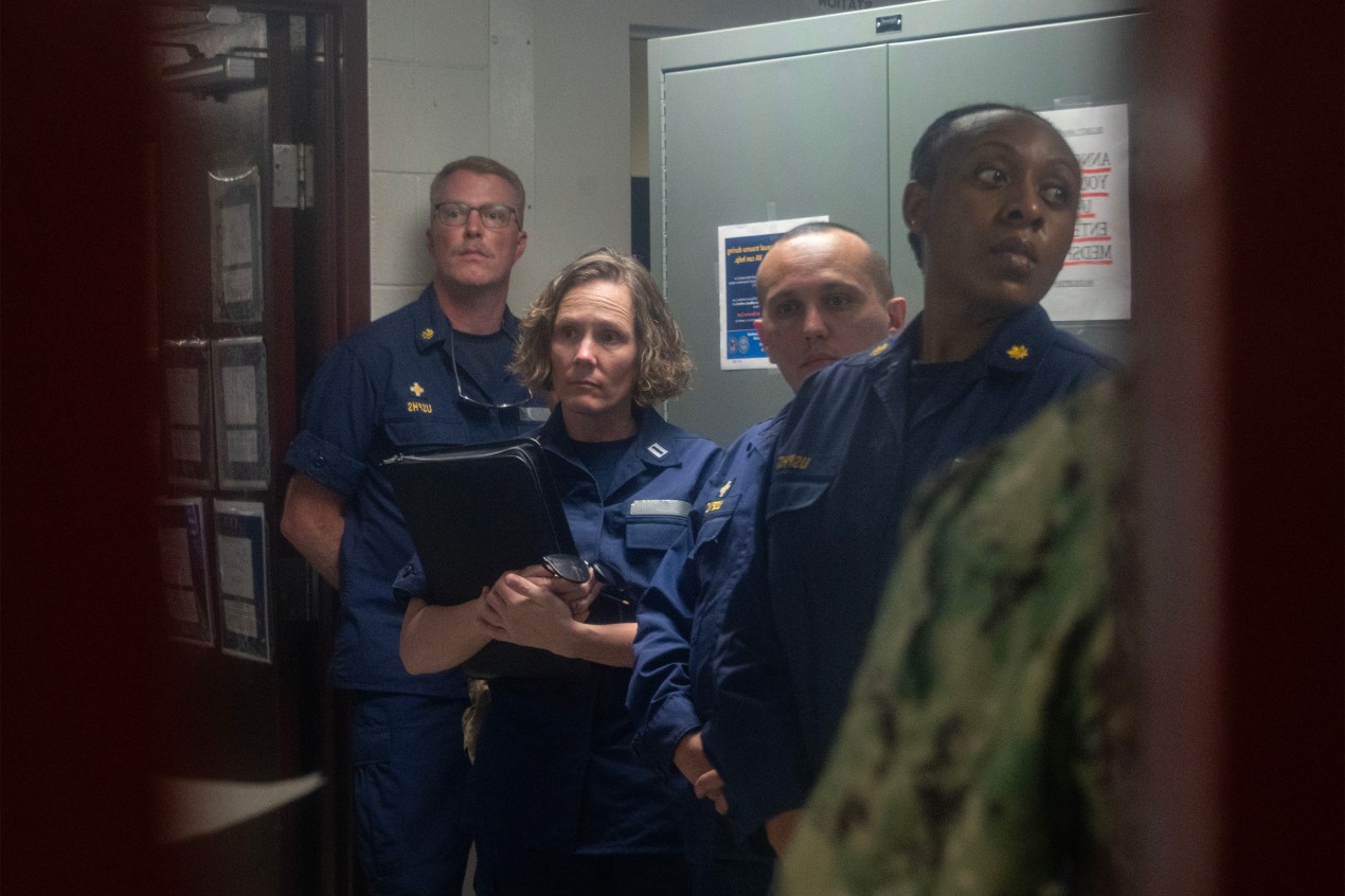 Four uniformed U.S. Public Health officers look out of frame.