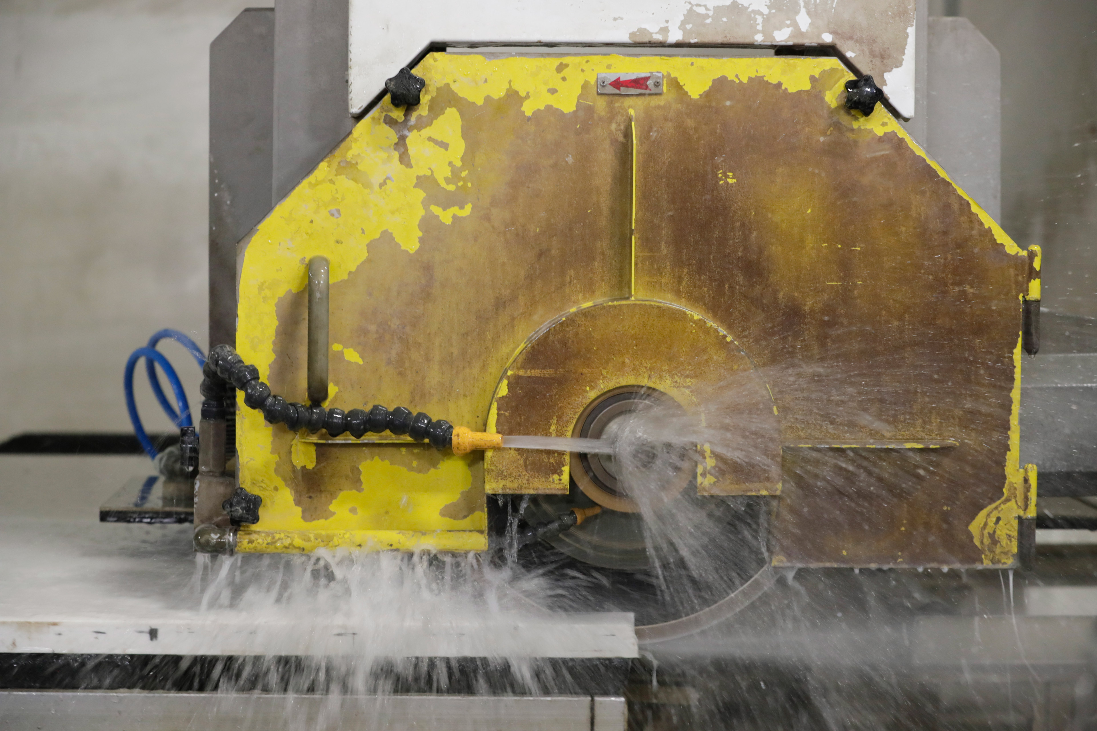 A close-up showing a quartz slab being cut with a wet saw.