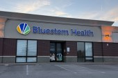 An exterior of a health clinic with a blue sign that reads, "Bluestem Health."