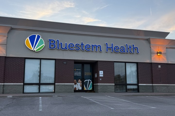 An exterior of a health clinic with a blue sign that reads, "Bluestem Health."