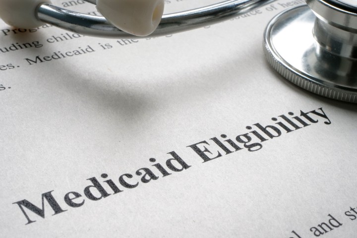 A sheet of paper says "Medicaid Eligibility" with a stethoscope resting on top.