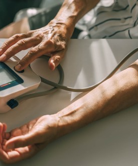An elderly woman takes her blood pressure at home. Unrecognizable person, hand close-up.