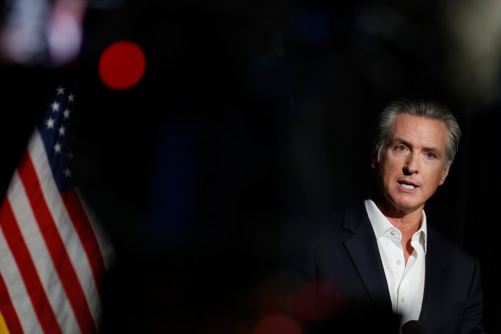 California governor Gavin Newsom stands before an American flag