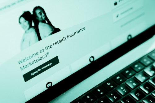 The healthcare.gov website seen on a laptop. The webpage reads, "Welcome to the Health Insurance Marketplace. Apply for coverage."