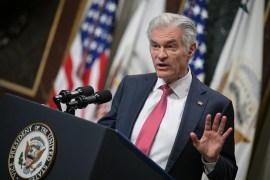 A photo of Mehmet Oz speaking at a podium at the White House. American flags are seen behind him.