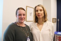 Two women with blonde-ish hair stand side-by-side in a doctor's office.