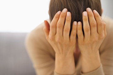 Stressed young woman sitting on couch