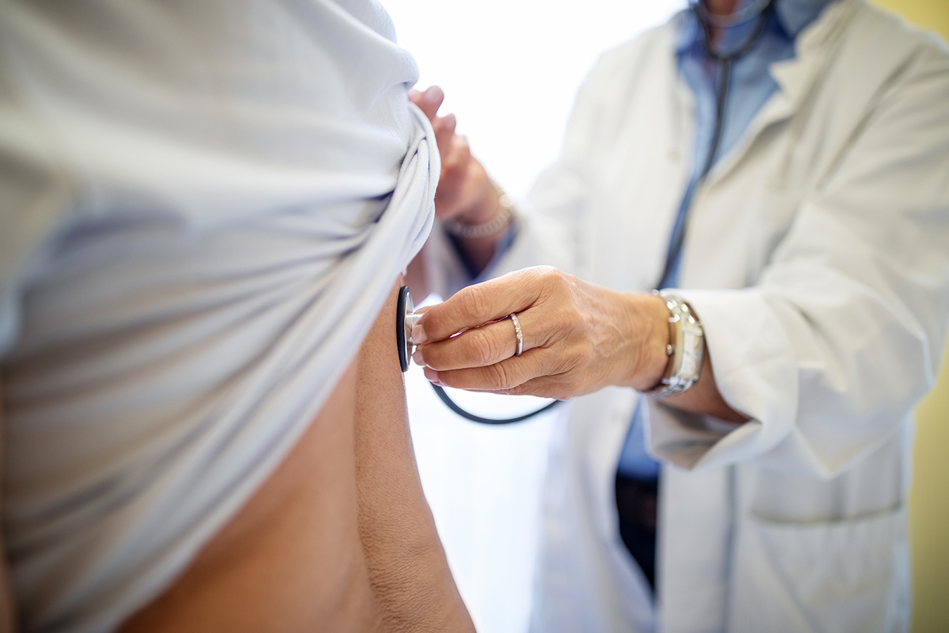 Female doctor examining patient with stethoscope
