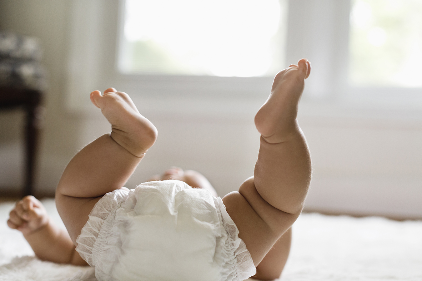 baby laying on floor with diaper