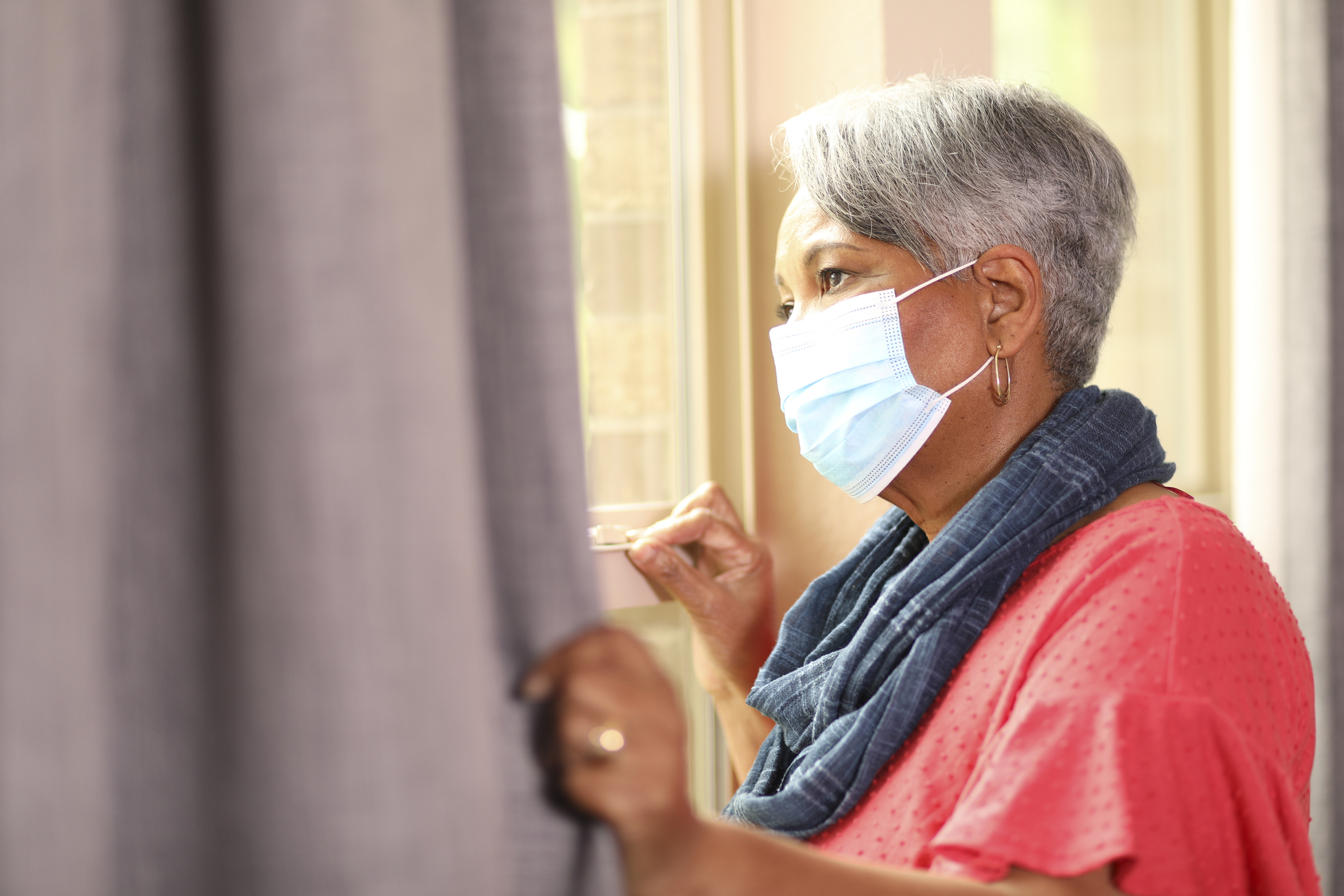senior woman looks out window