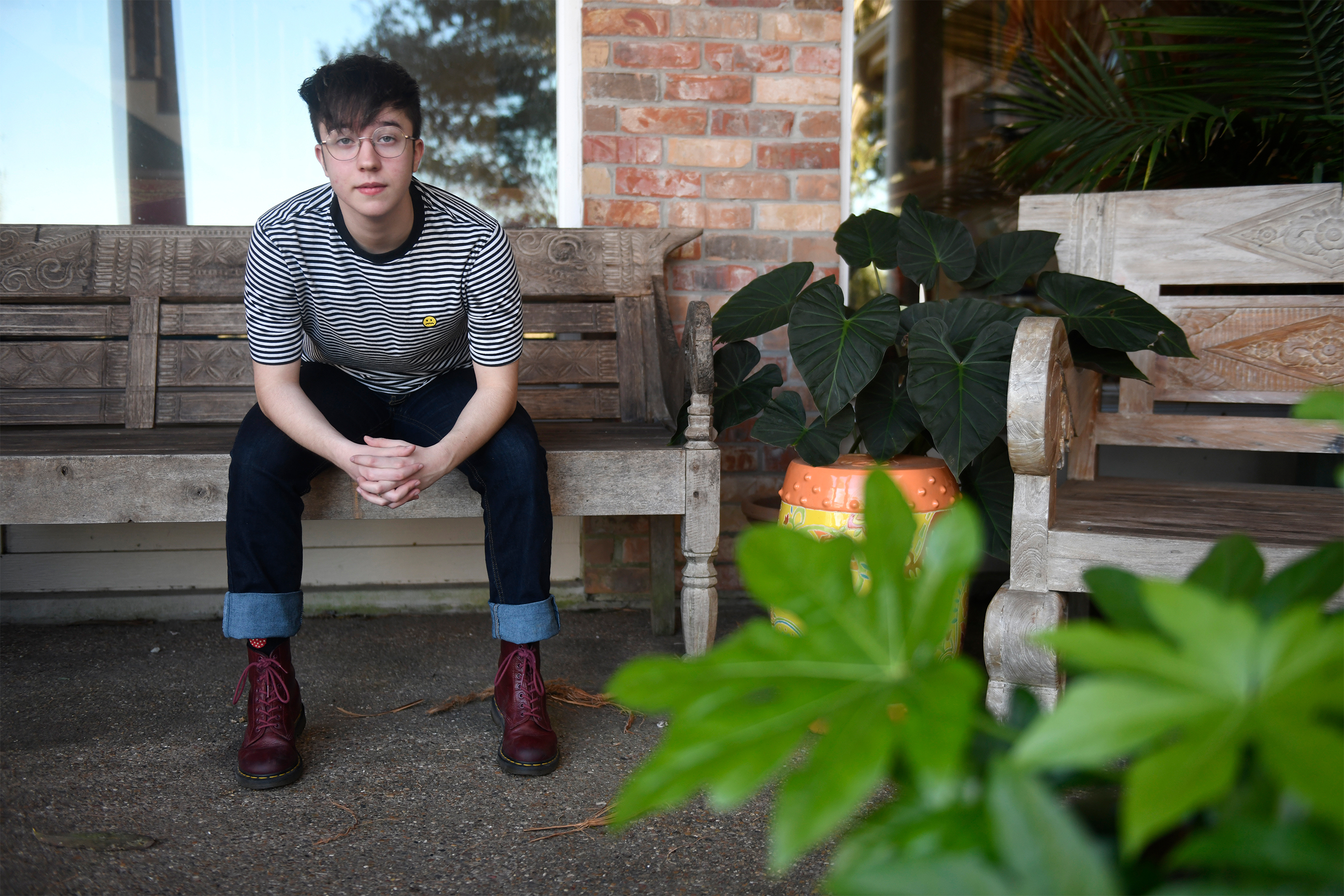 Charlie Apple sits on a bench outside his home.