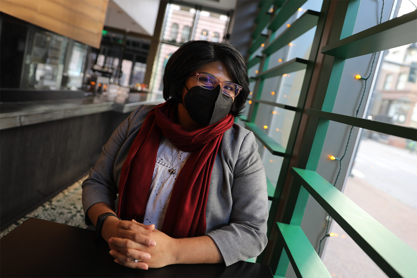 Qiana Torres Flores is seen by a window inside the French 75 restaurant.