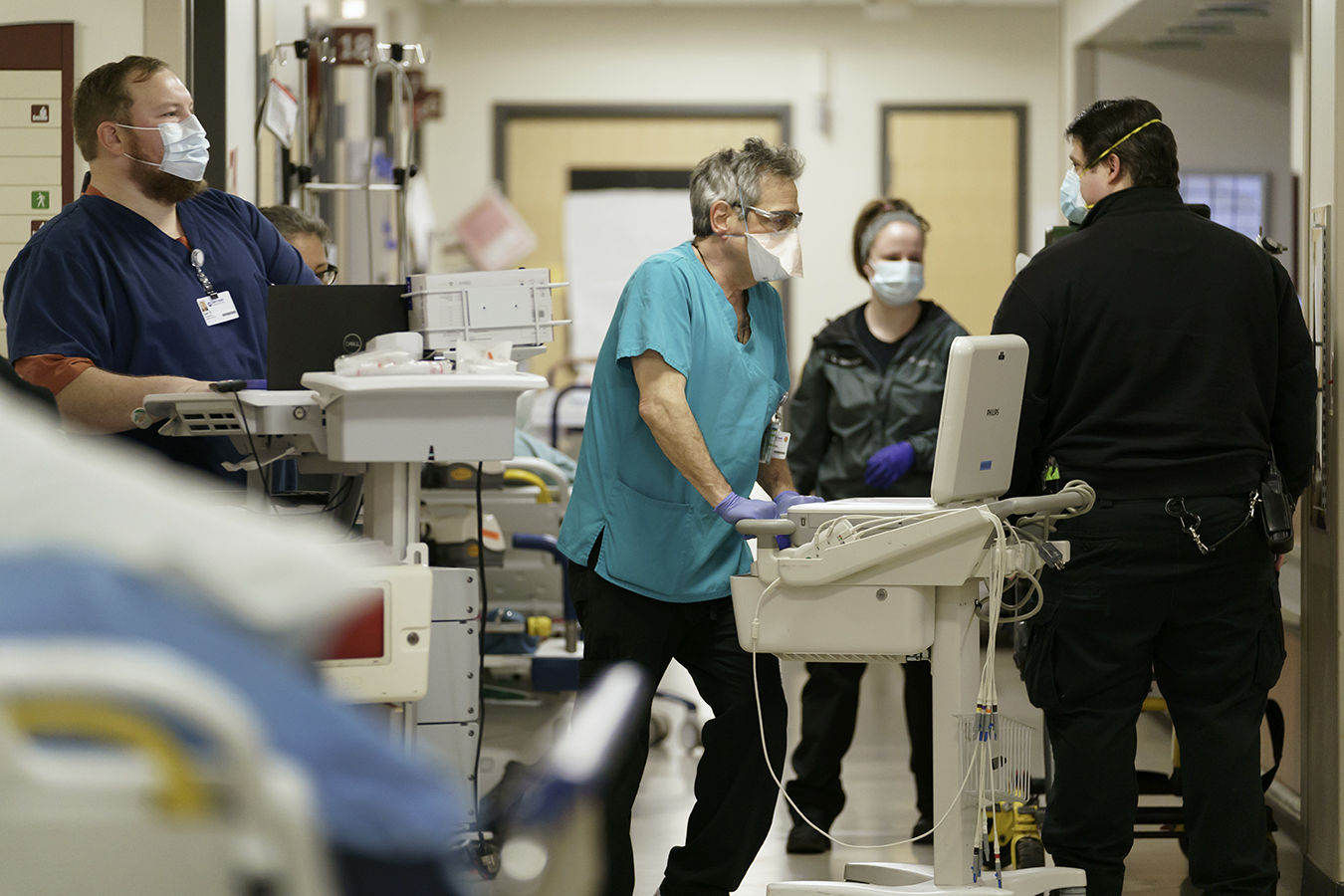 Four staff wearing masks in a hospital hallway