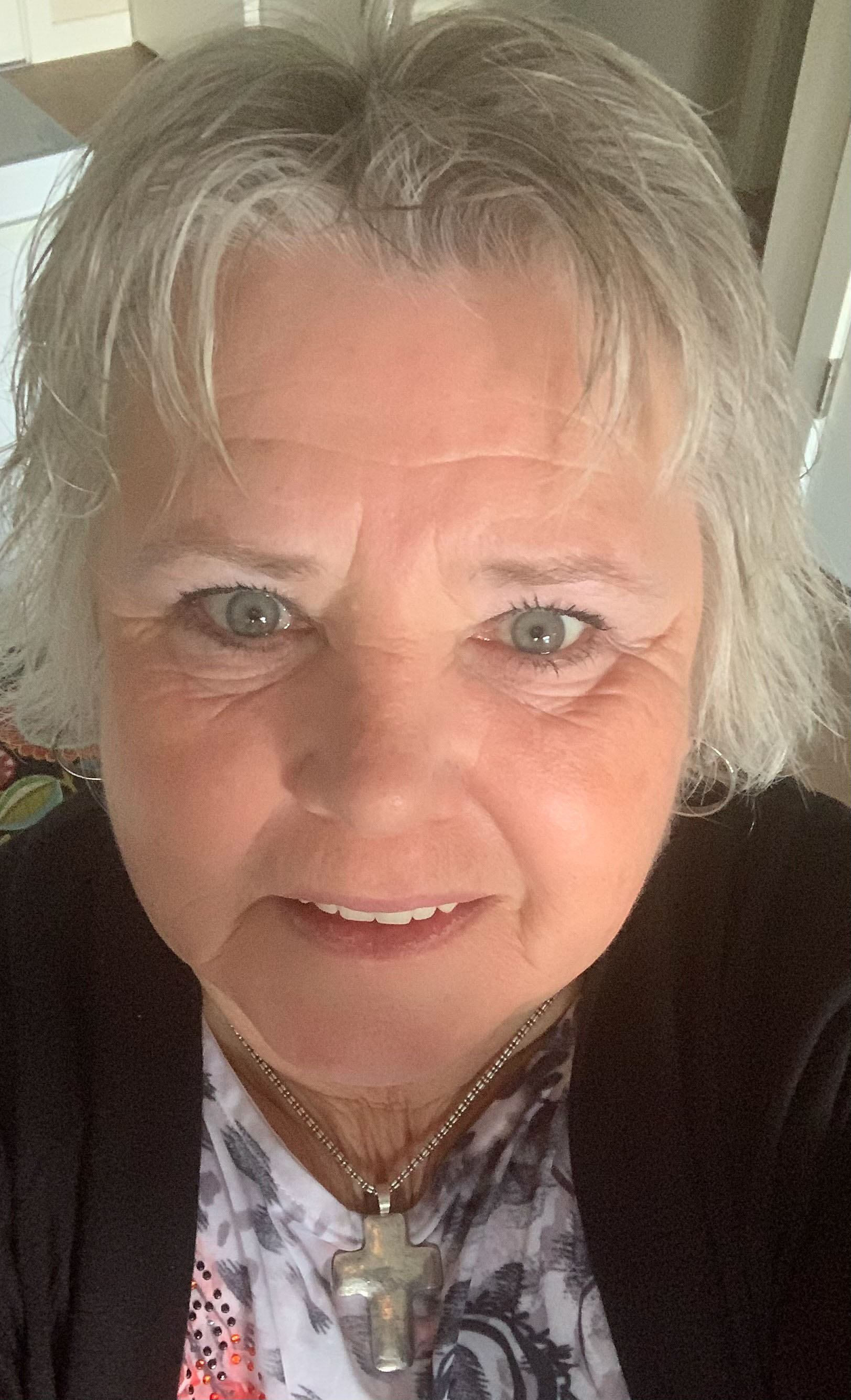 Christine Thelker looks up at the camera while taking a selfie.