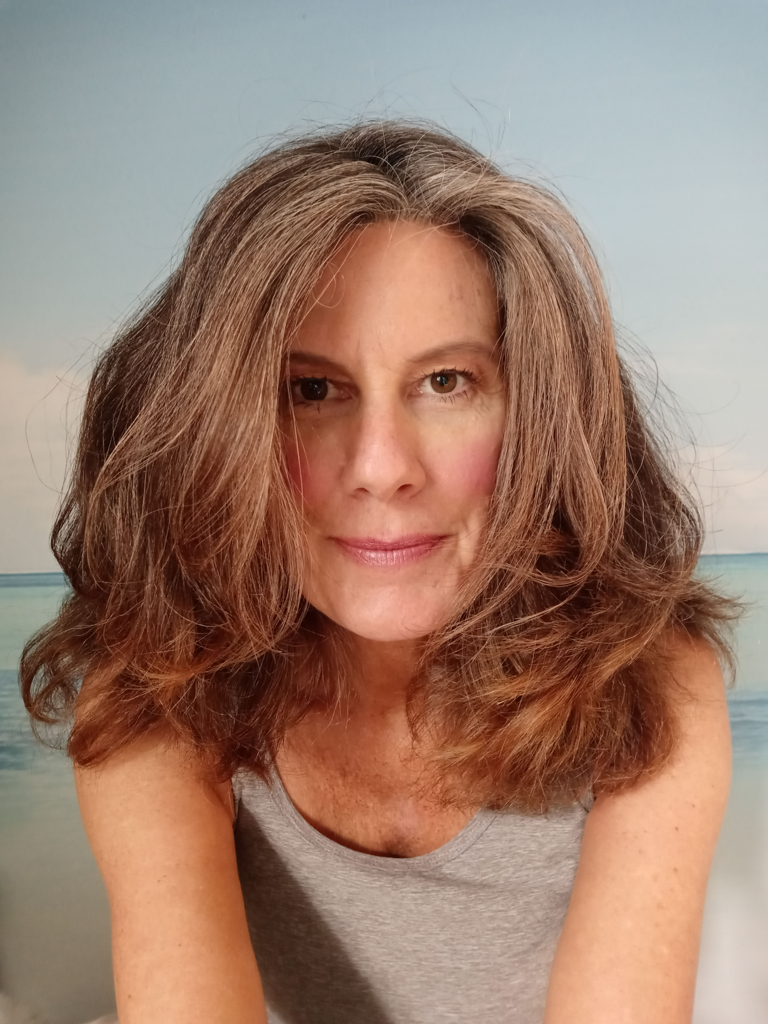 Joanna Fix leans forward towards the camera as her shoulder-length hair frames her face.