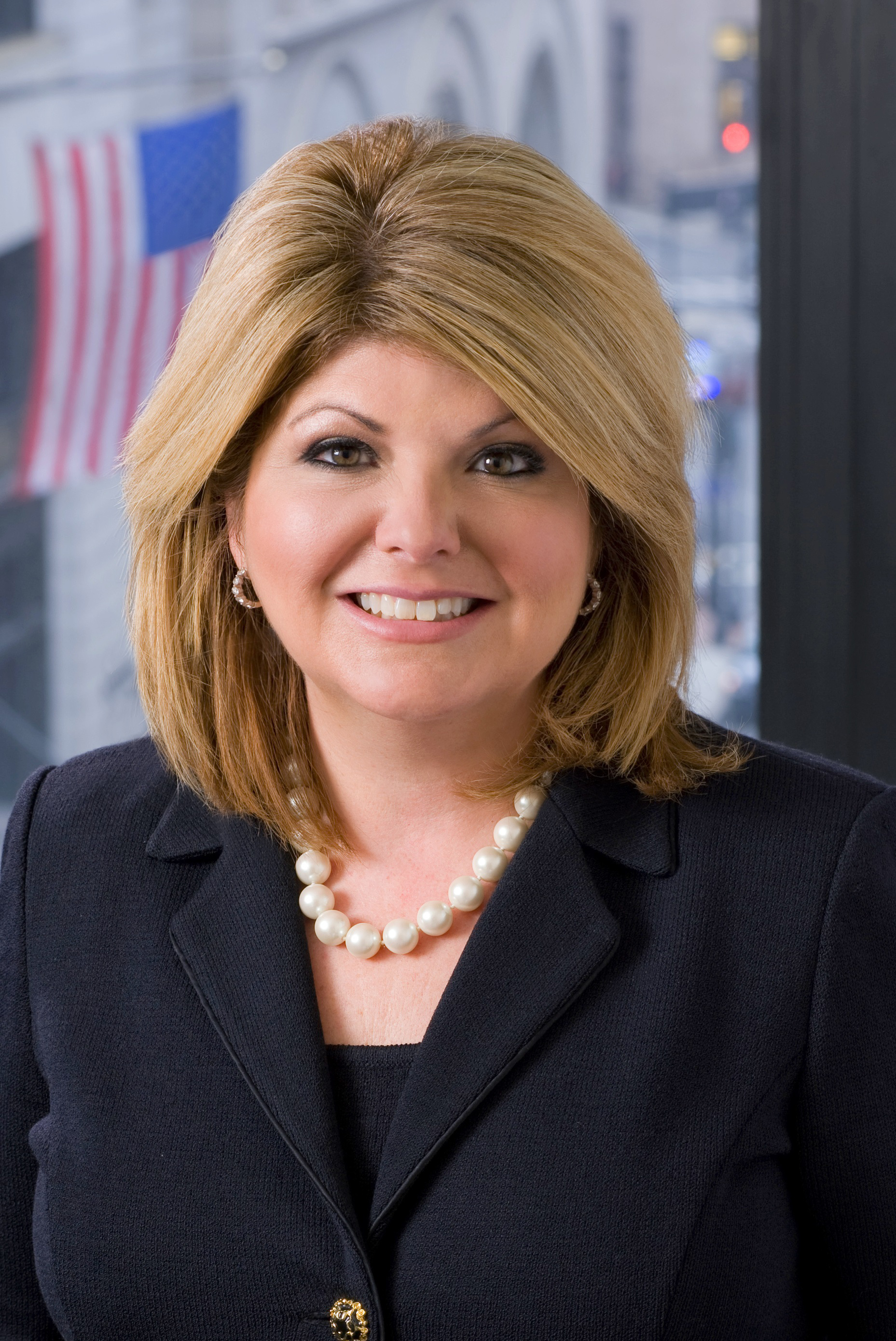 Lora Pellegrini is seen smiling in a headshot portrait.