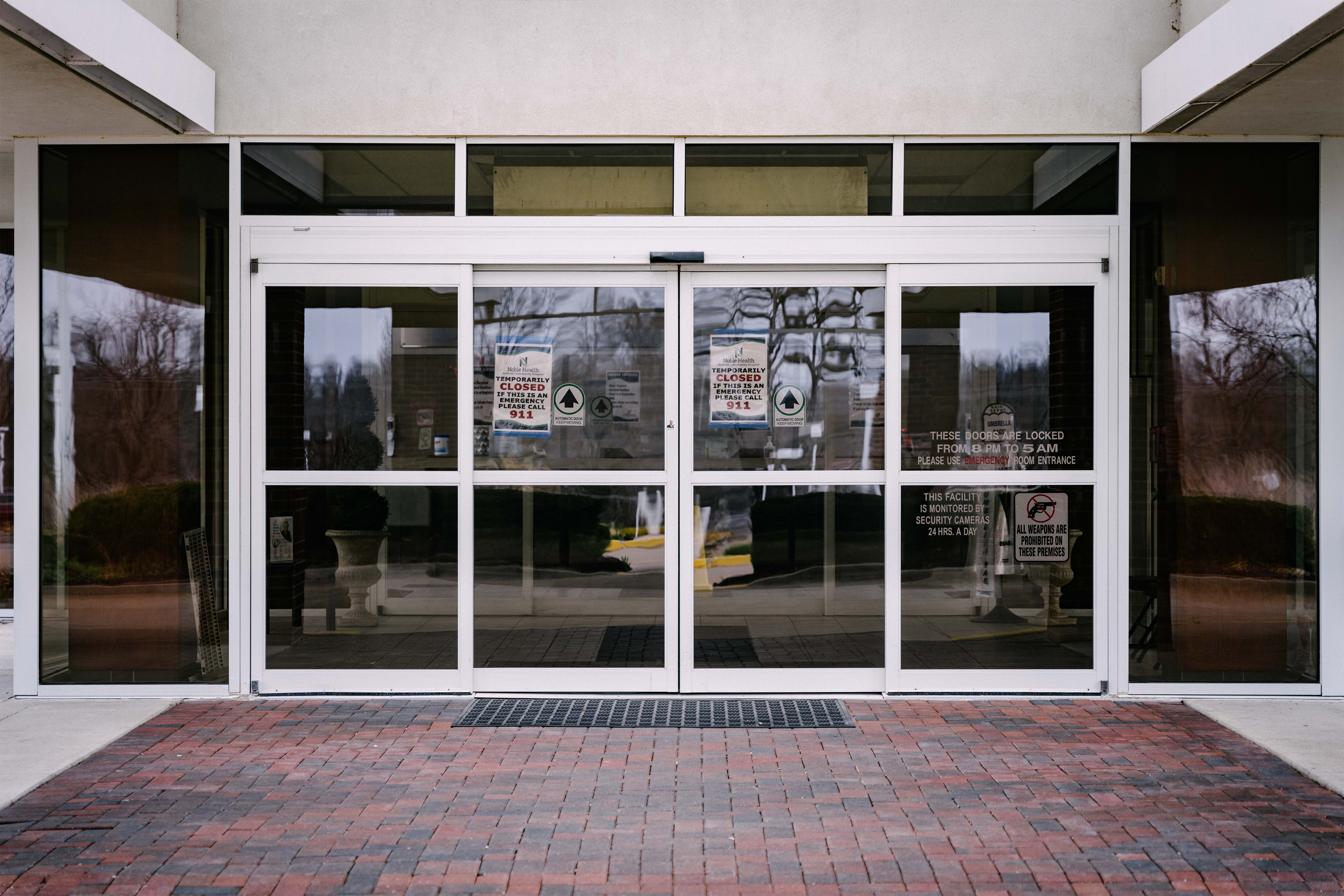 A photo shows the entrance to Audrain Community Hospital from outside.  Signs posted on the door read, "Temporarily closed. If this is an emergency, please call 9-1-1."