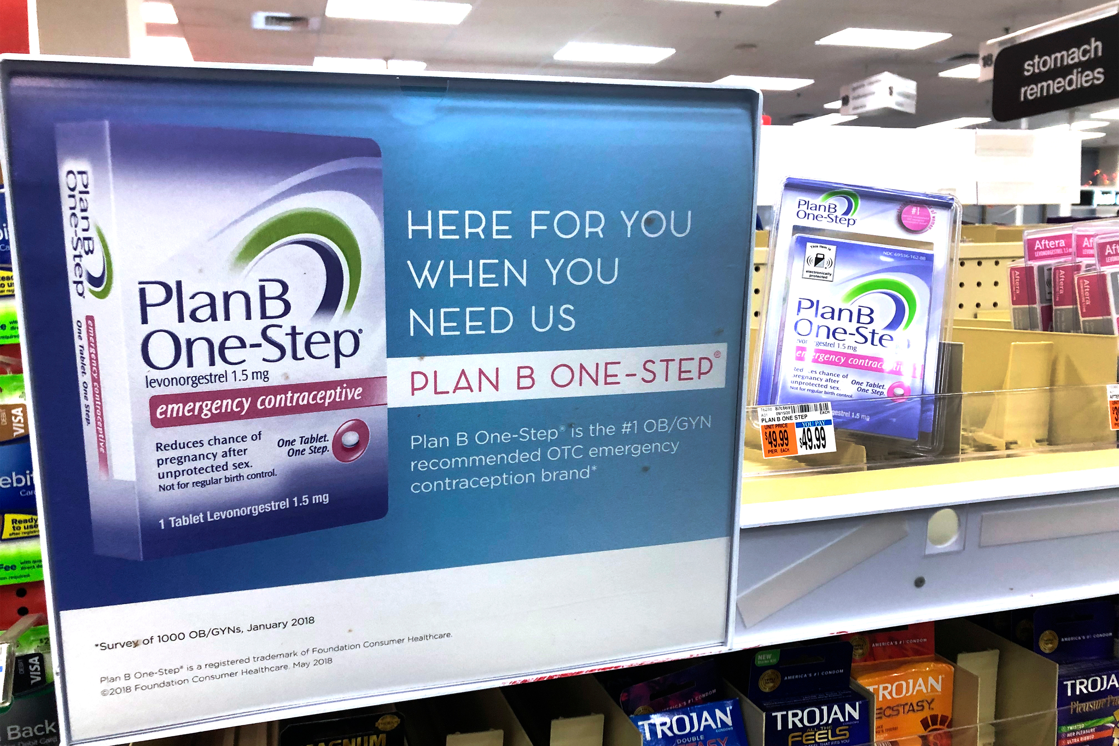 A photo shows an advertisement for Plan B inside of a pharmacy. Text on the sign reads, "Here for you when you need us. Plan B One-Step."