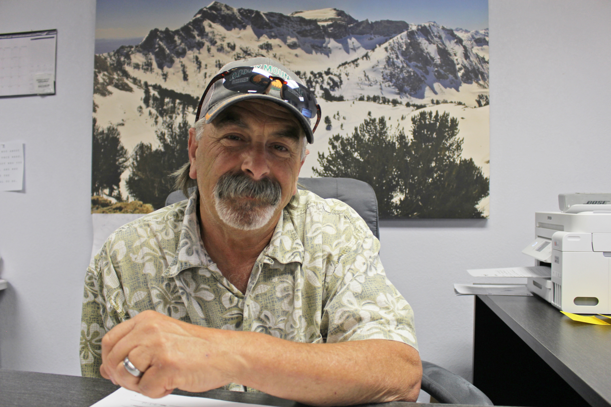 A photo shows Richard Cusolito posing for a portrait while at his desk.