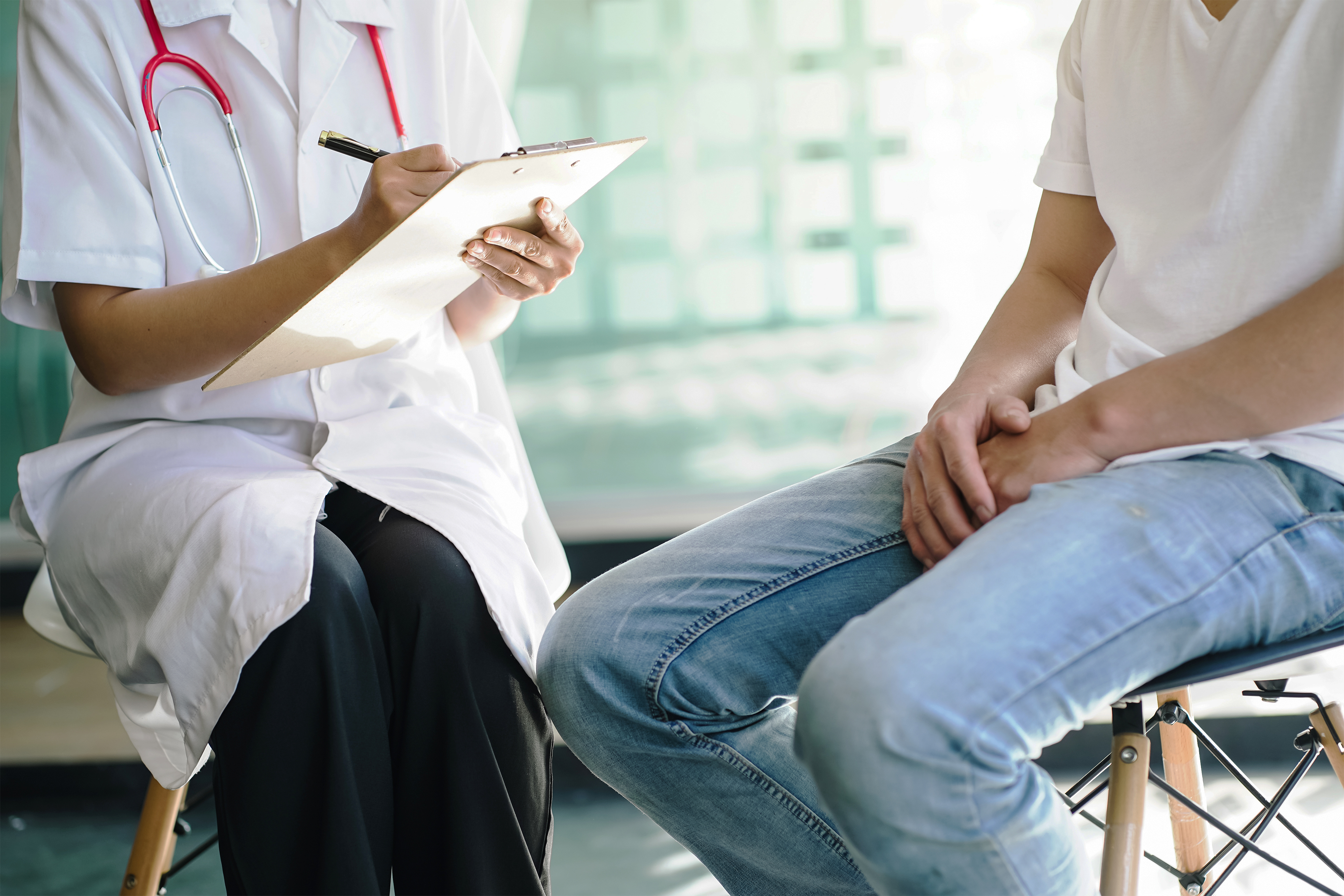 A photo shows a man sitting across from a doctor.