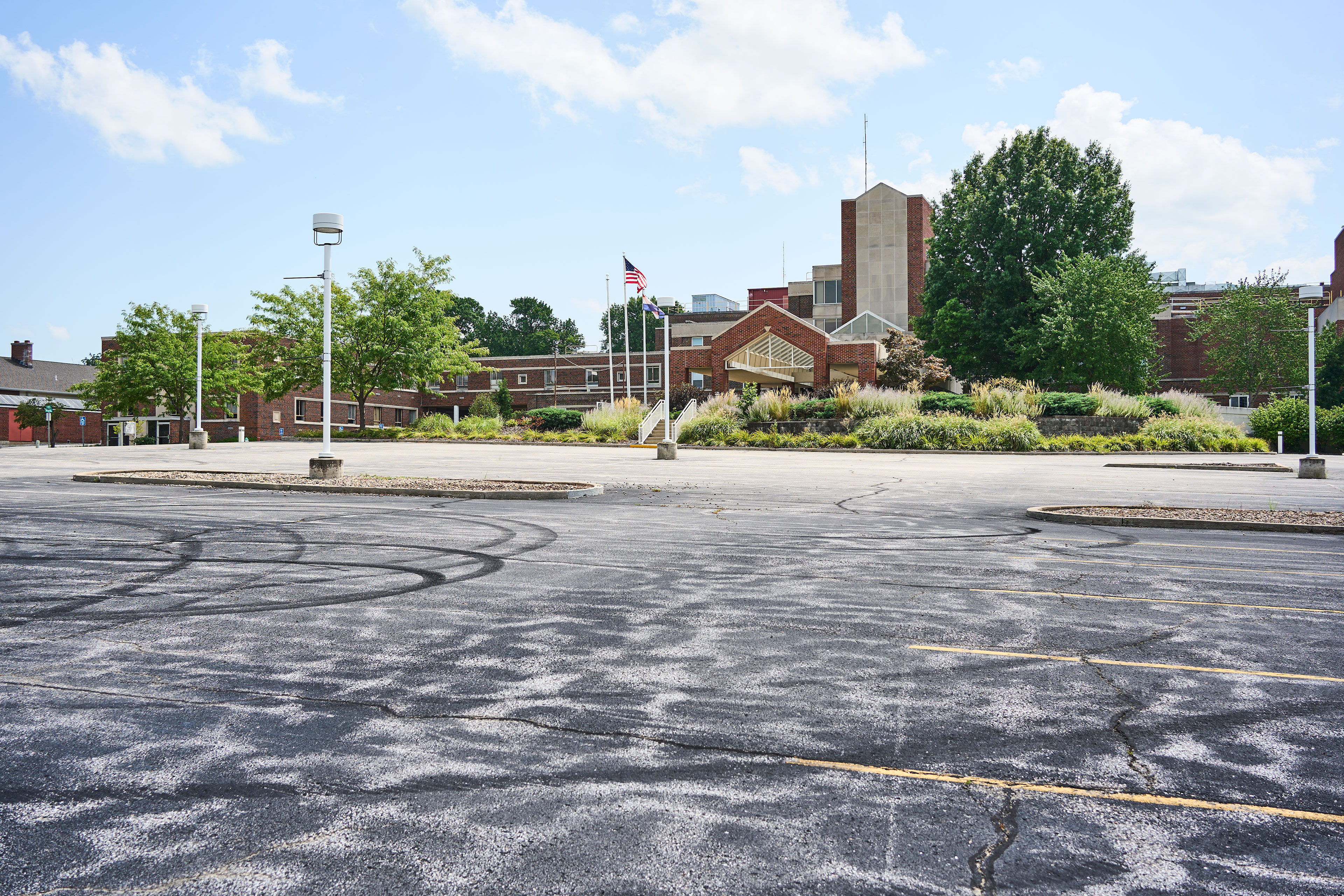 An empty parking lot in front of a hospital building.