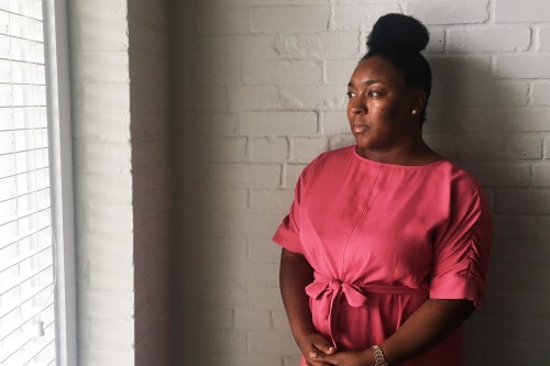 A photo shows J.R. Chester standing beside a window to the left. She is looking out the window.