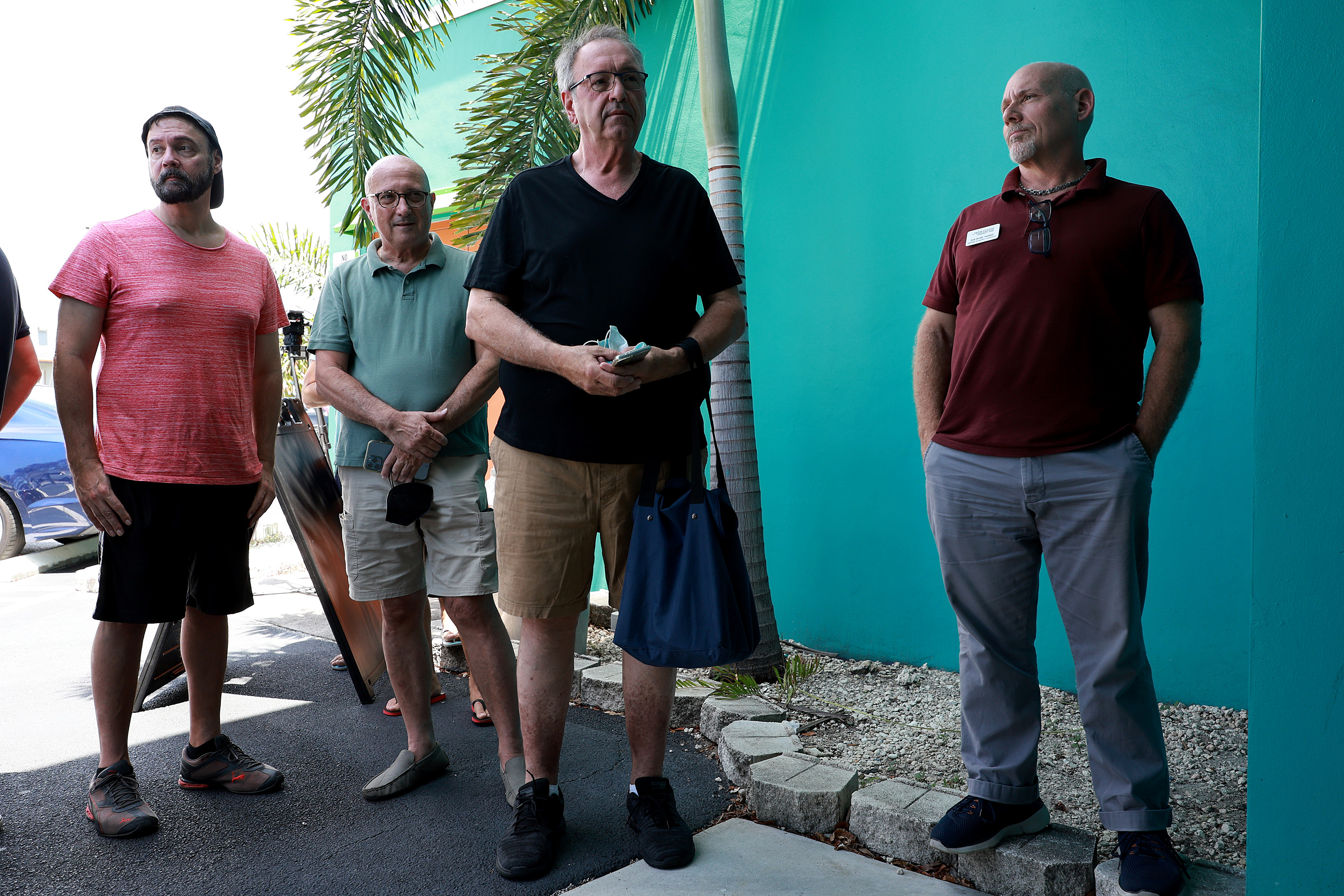 A photo shows men in line outside of a building. They are waiting to get a free monkeypox vaccine.