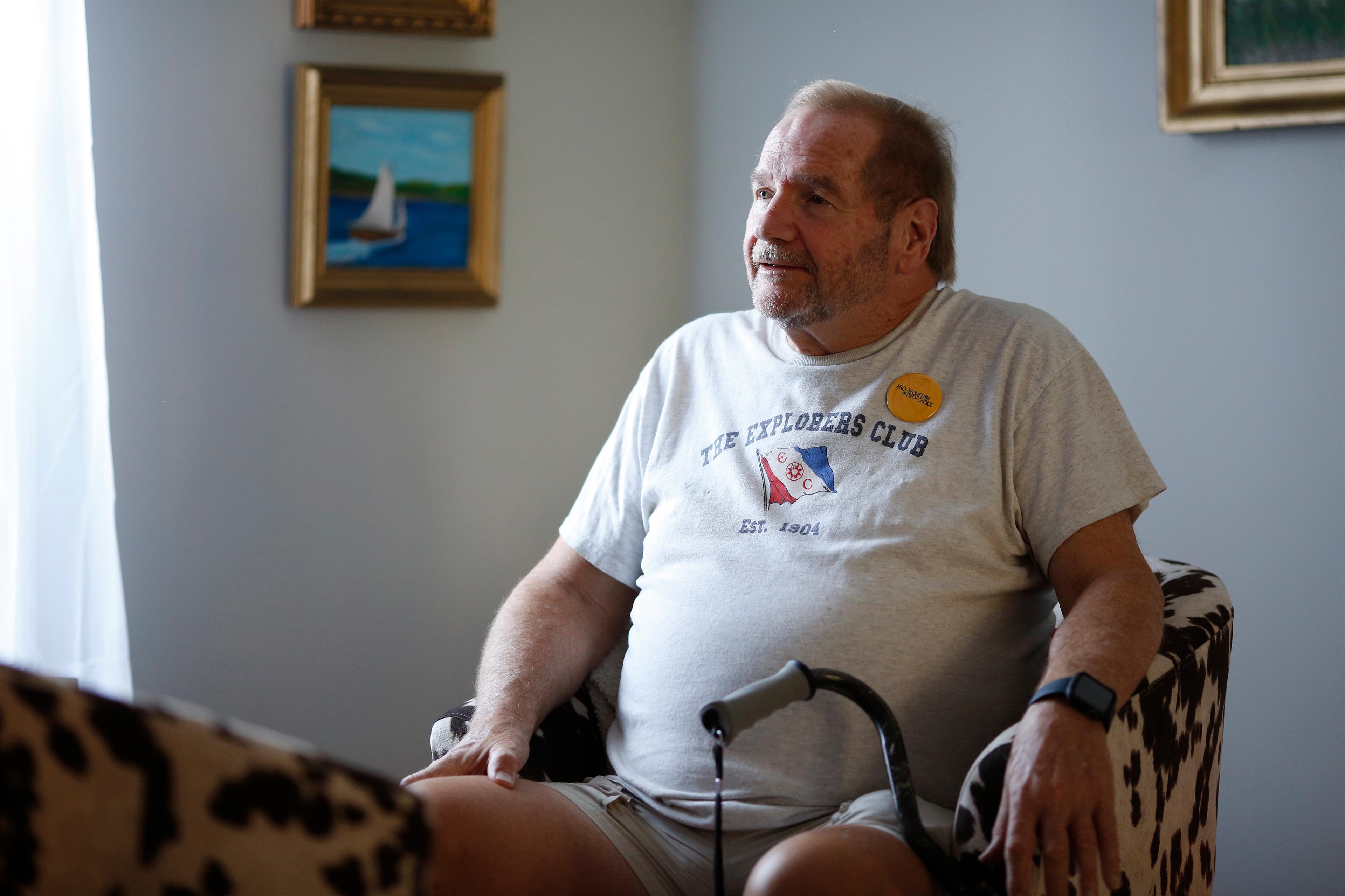A photo shows Jerry Bilinski sitting at home by a window.
