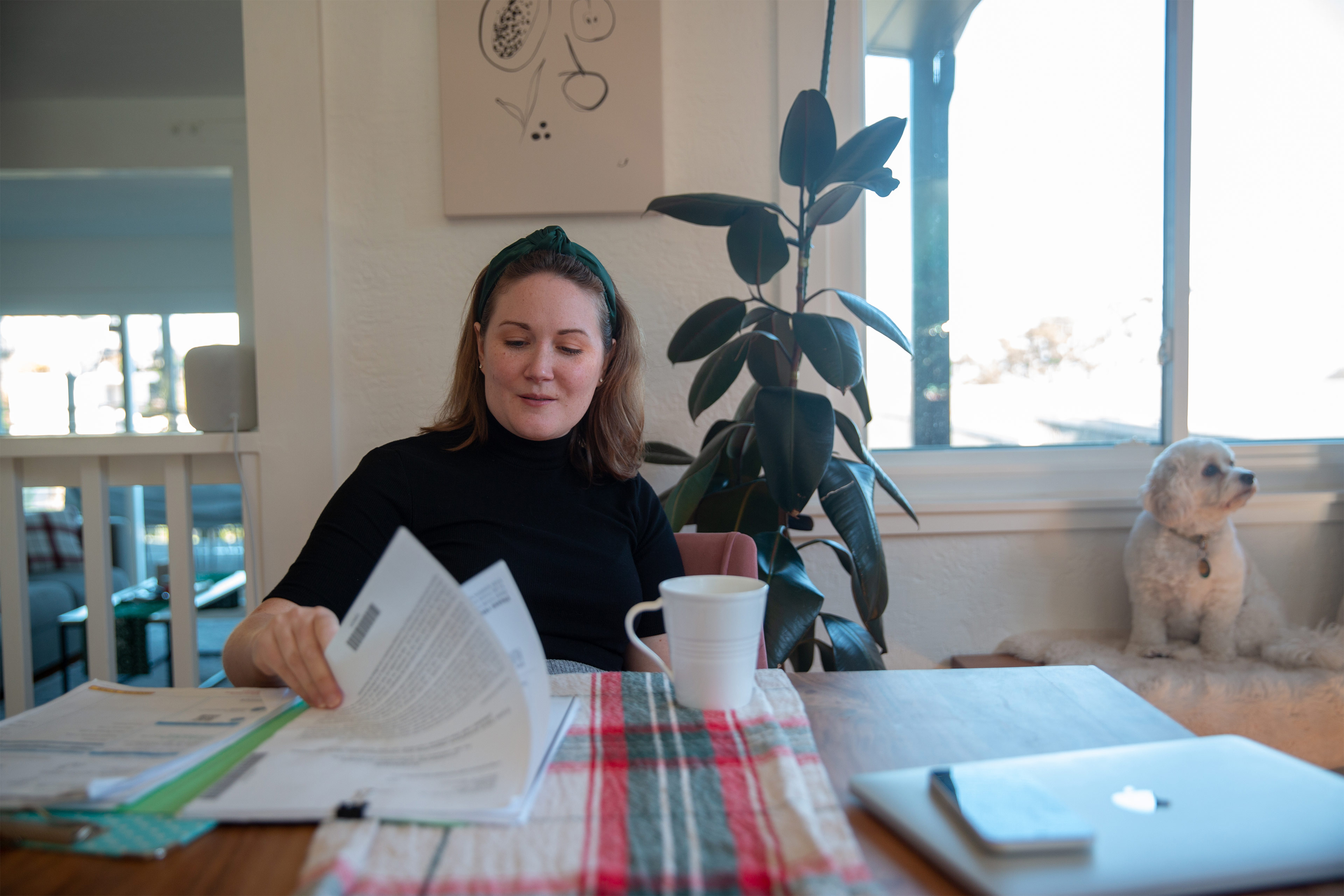 A photo shows Grace E. Elliott sitting at a table at home, looking through paperwork.