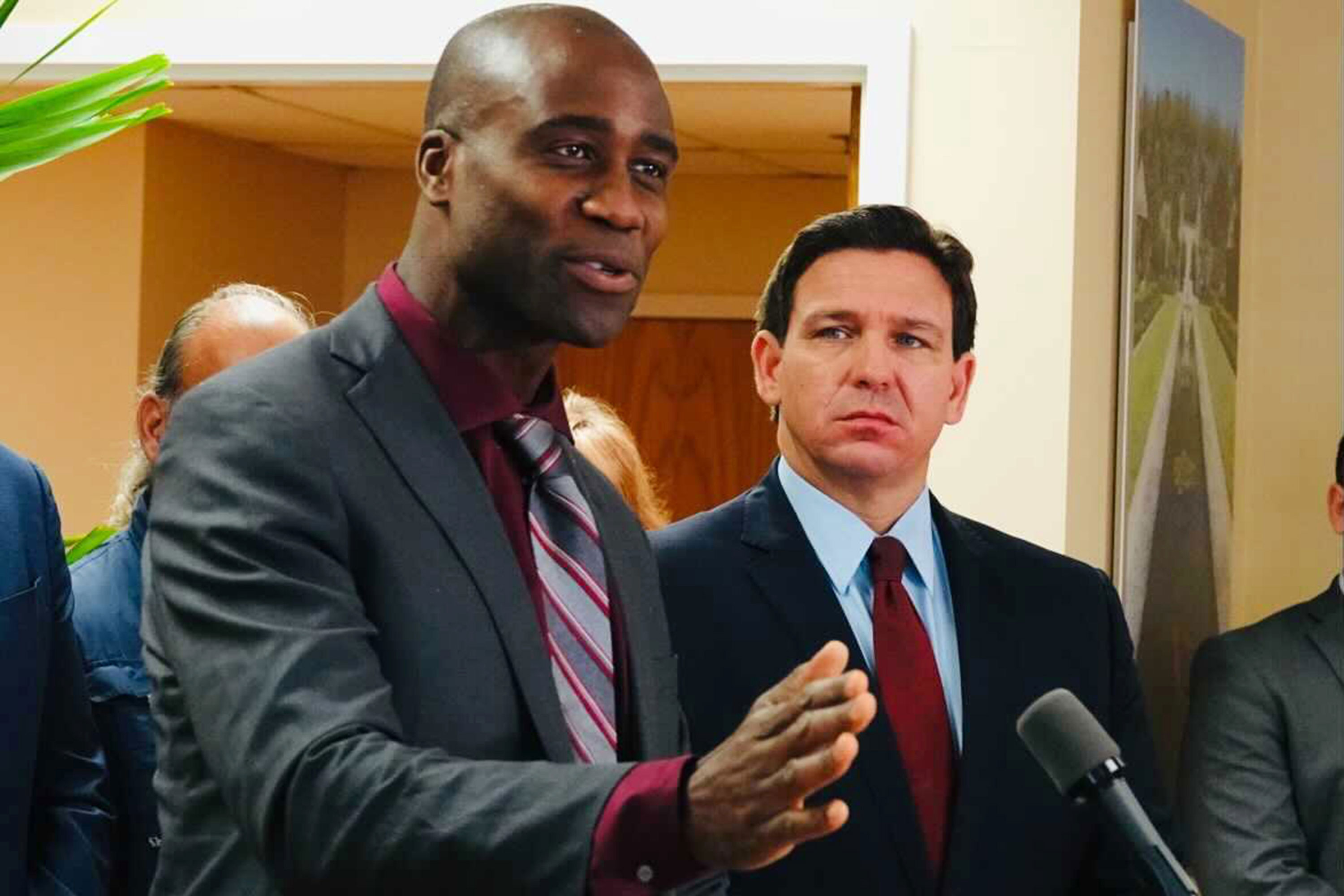 A photo shows Joseph Ladapo and Ron DeSantis at a news conference.