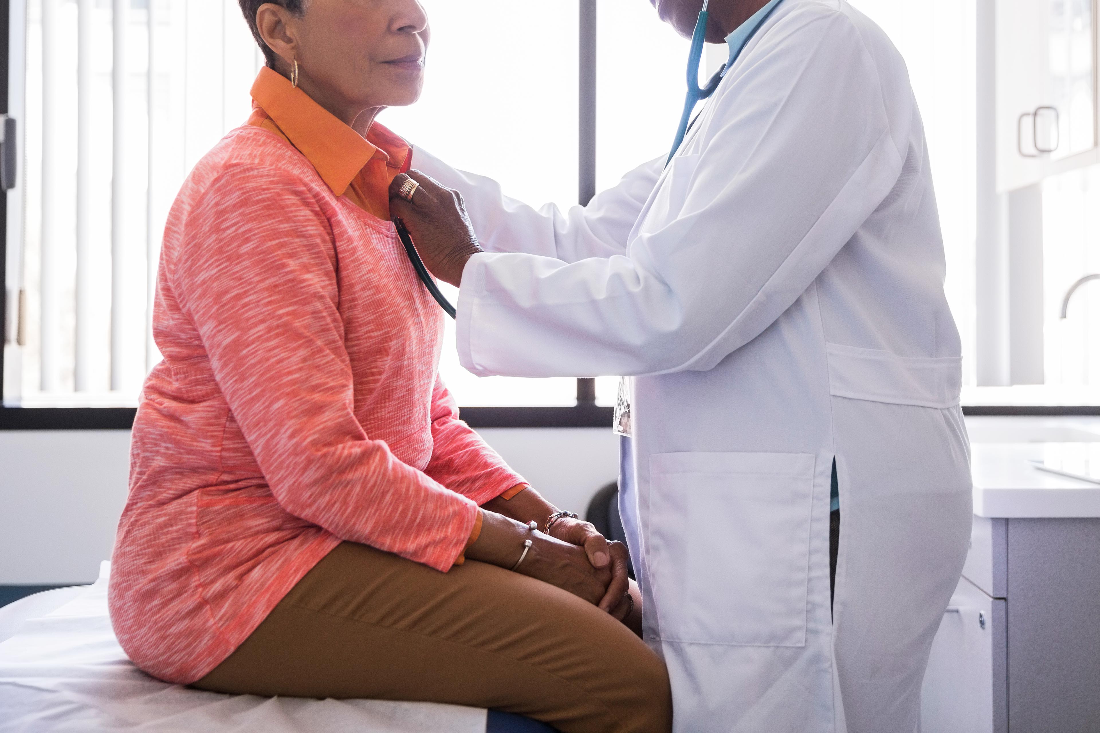 A photo shows a doctor using a stethoscope on an older woman.