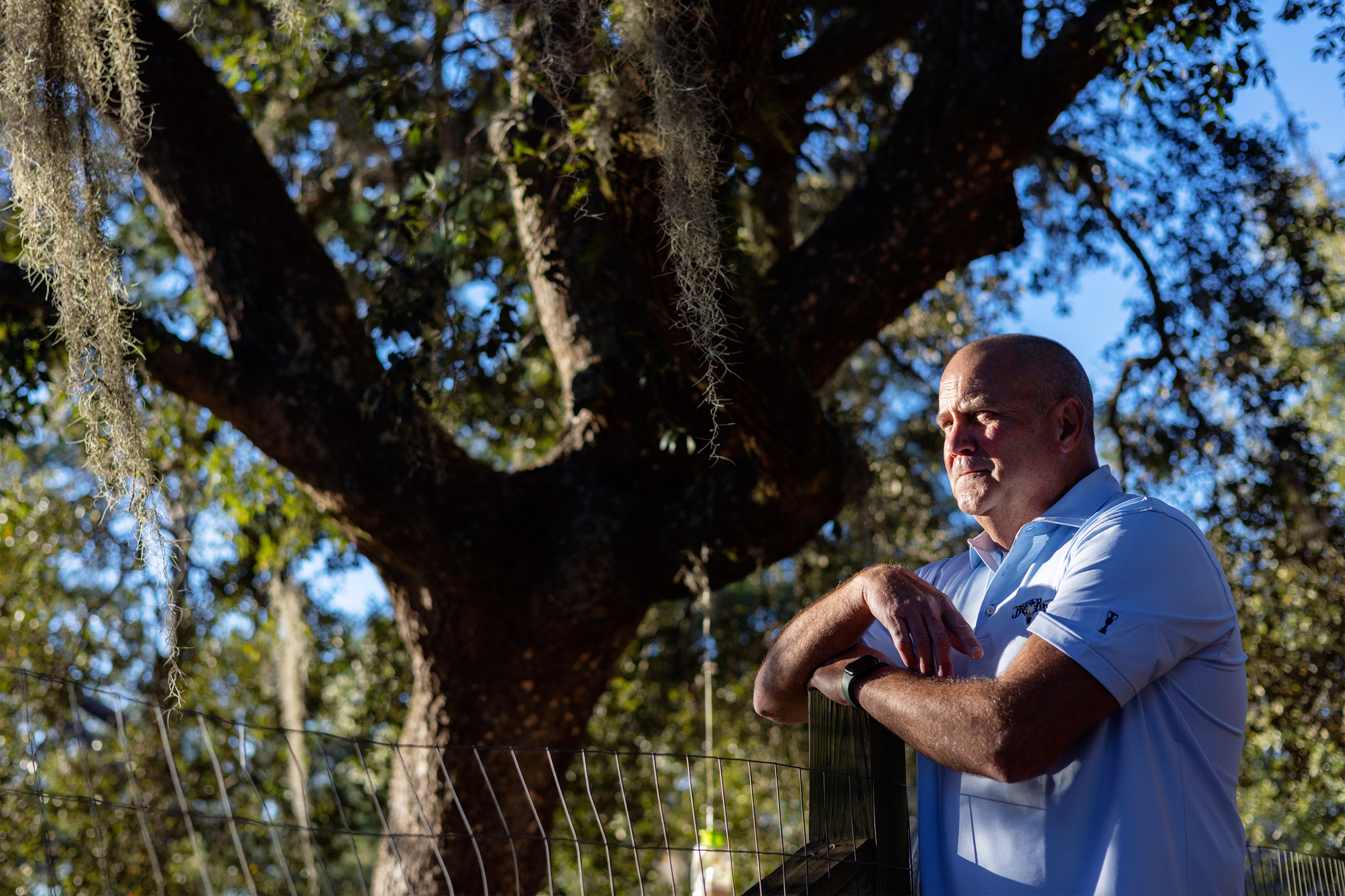 A photo shows John Lites posing for a photo outdoors. He's standing by a fence.