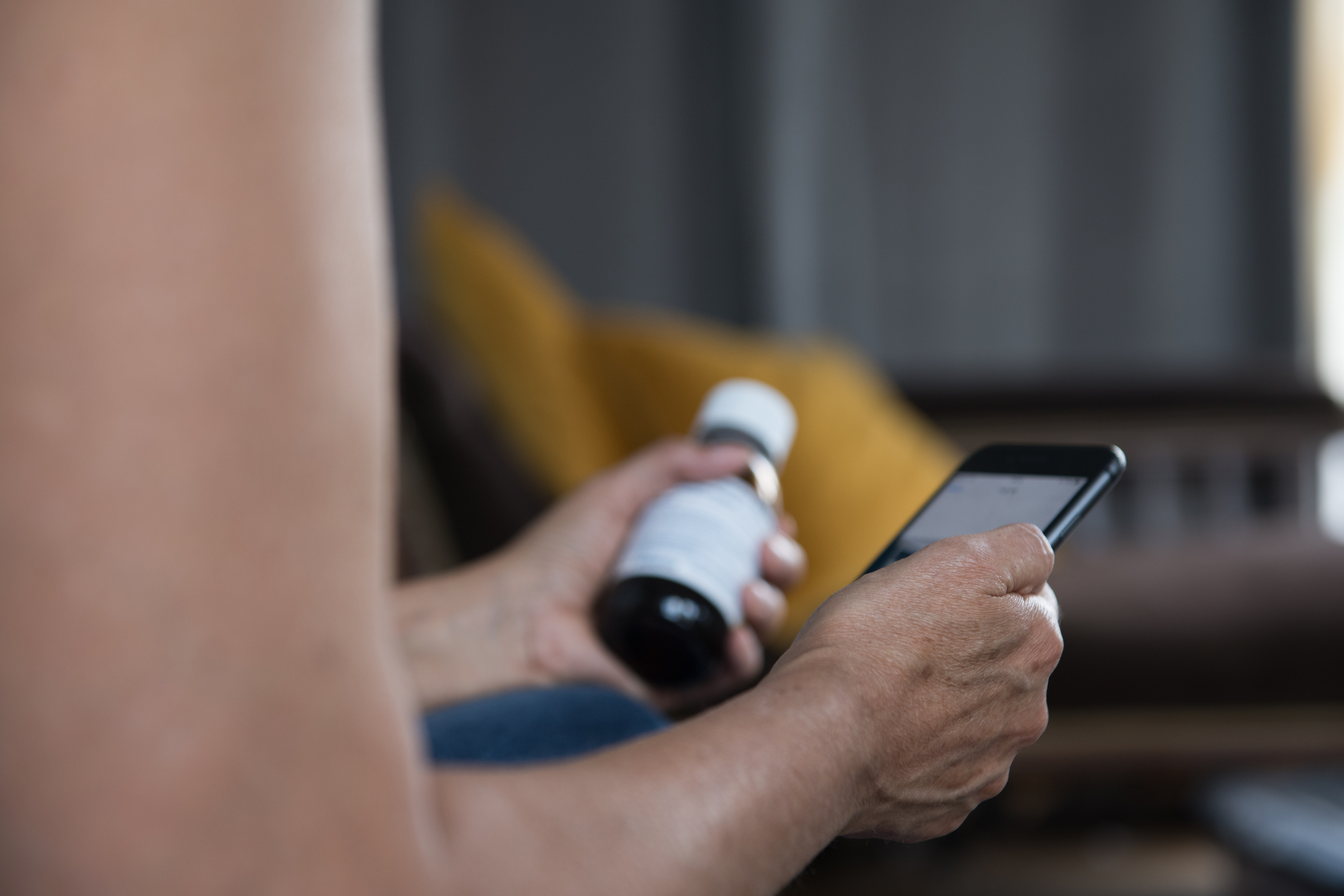 Unrecognisable mature woman with phone and medicine bottle