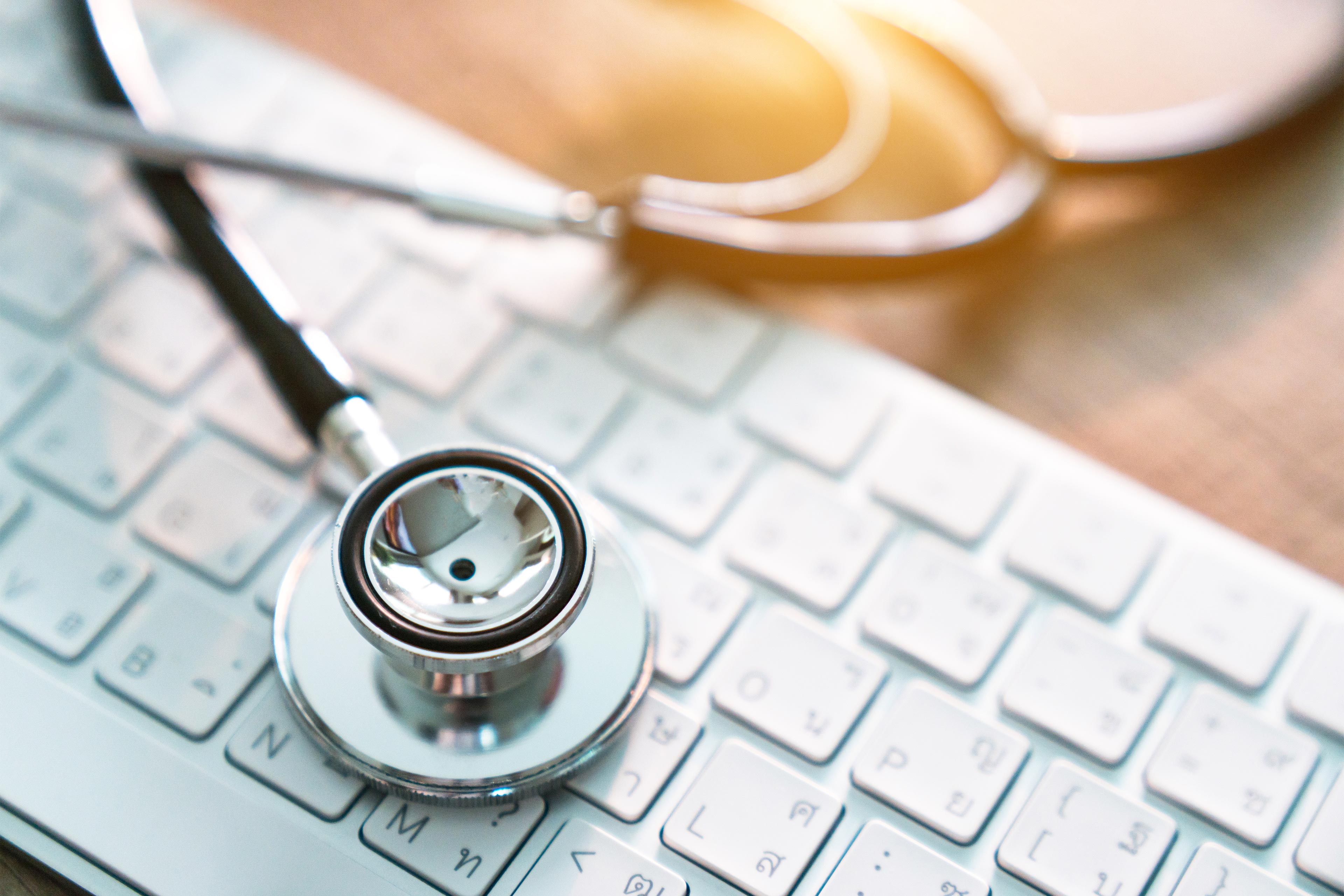 A photo shows a stethoscope resting on a computer keyboard.