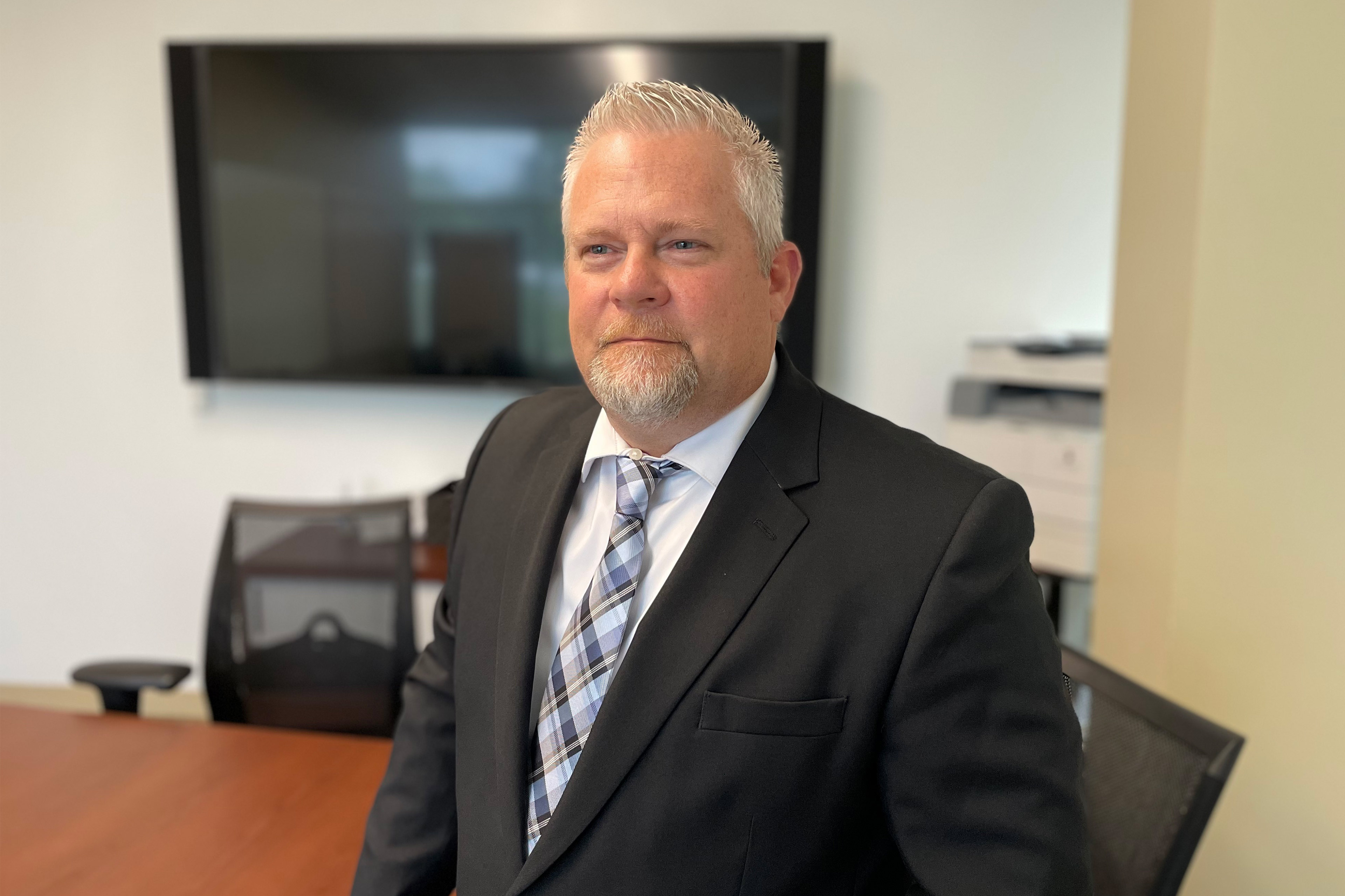 A photo shows Chad Holman standing in an office room.