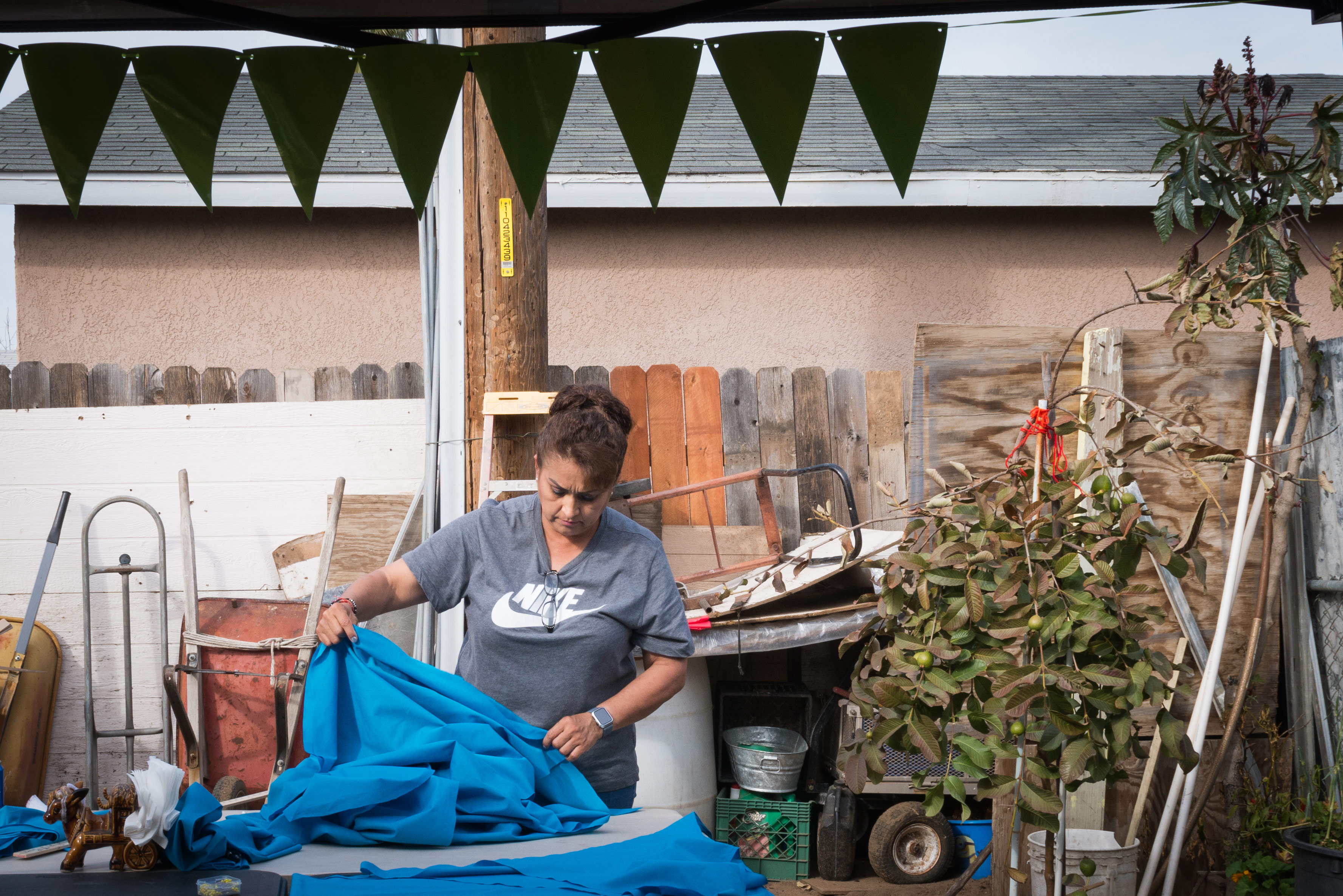 A photo shows a woman working with yards of fabric outside.