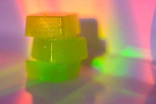 Stack of edible cannabis gummies in rainbow light