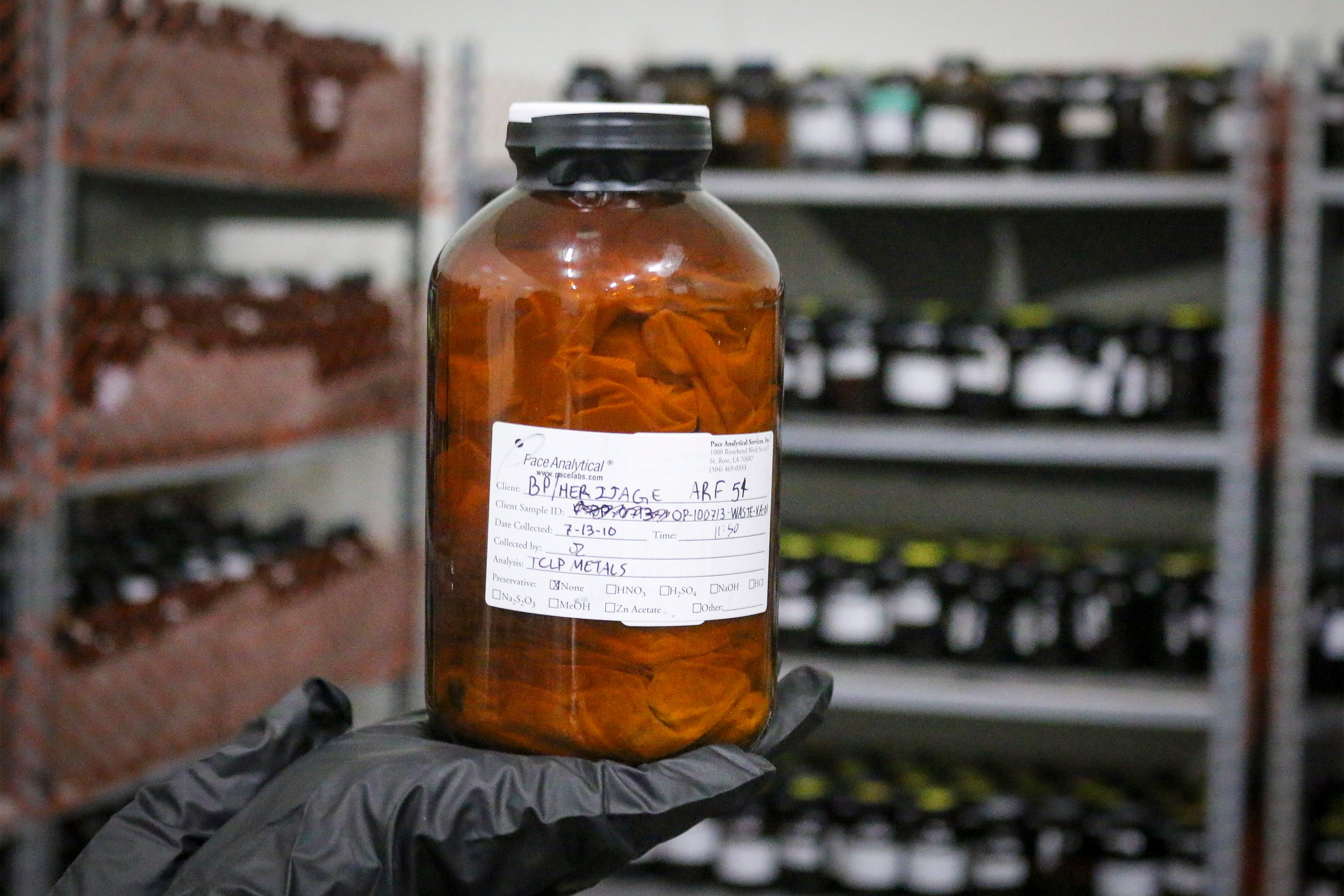 A photo shows gloved hands holding a jar with a cloth inside.