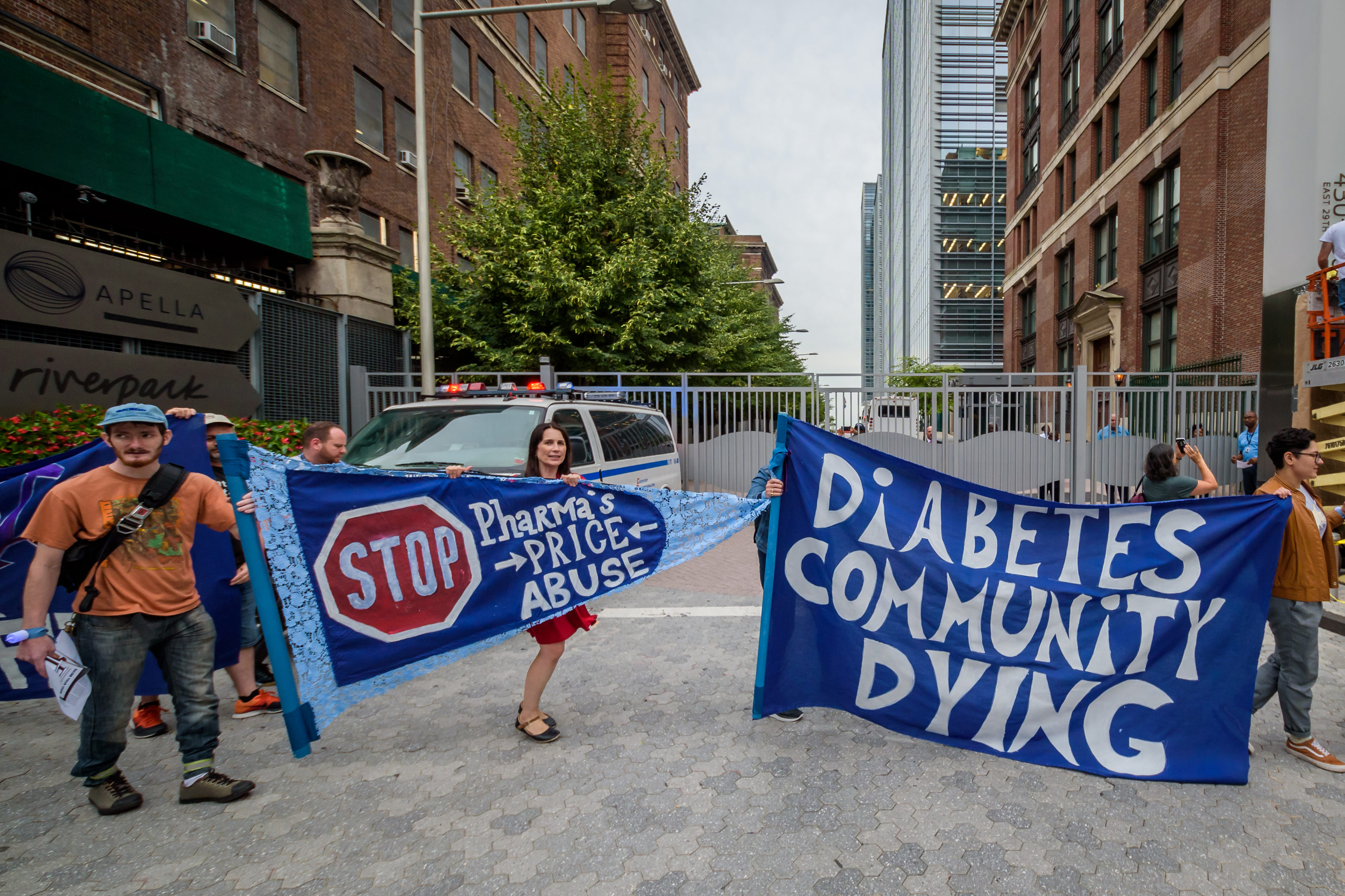 A photo of protesters holding signs that read, "Stop pharma's price abuse" and "Diabetes community dying."